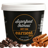 Superfood oatmeal container labeled 'Earnest Eats' with coffee beans and cinnamon sticks on a gray background